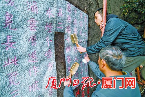 工作人员在脚手架上进行摩崖石刻的拓印。.jpg